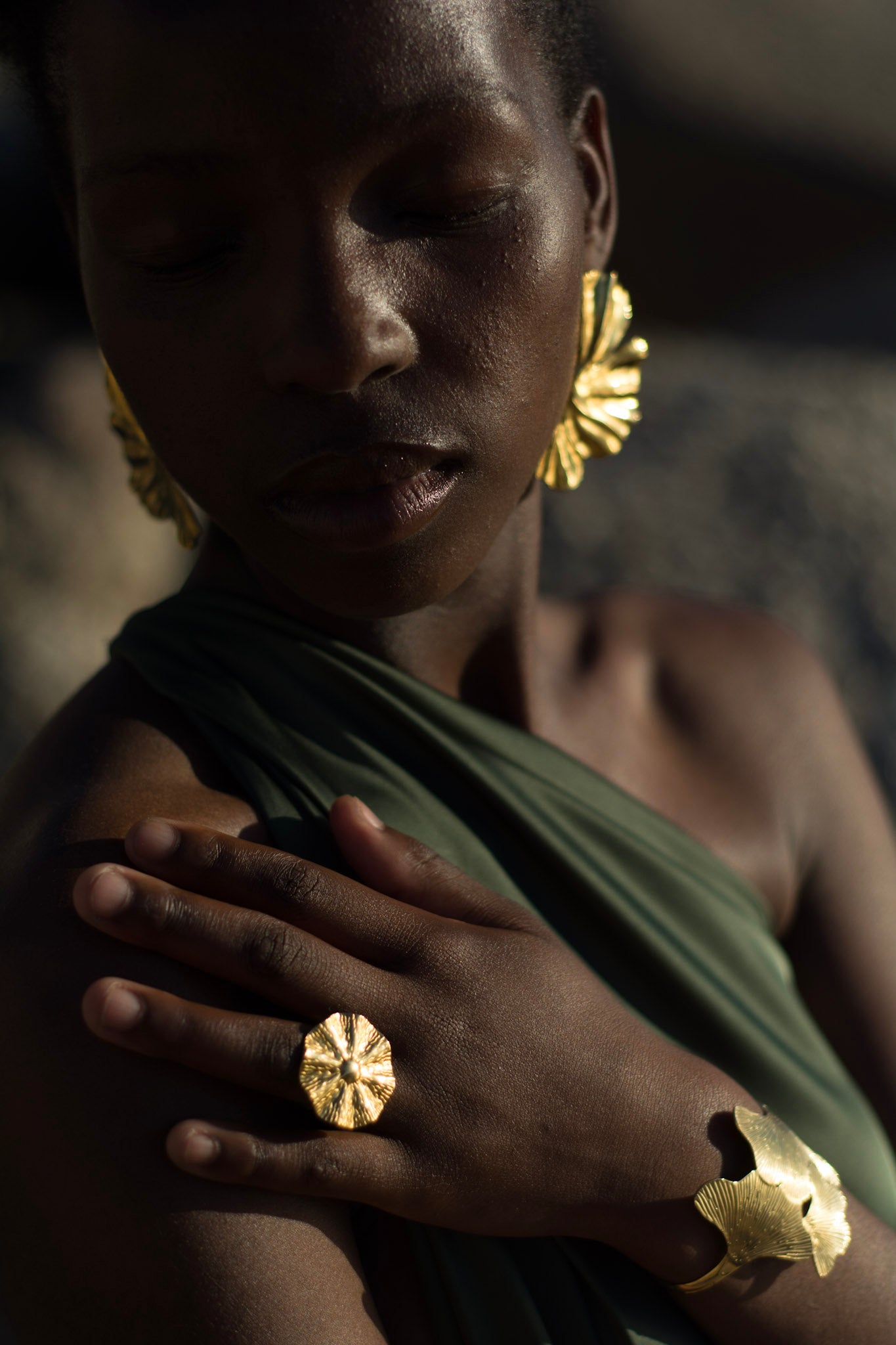 Woman wearing gold jewelry with a dark background